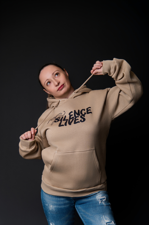 Тишината има форма. И тя е мека. „Silence Lives“ не е просто суичър – той е докосване до естествена материя, което напомня на нежен пандишпан. Създадена да се усеща, не просто да се носи – лека, мека, топла и комфортна. Самата кройка следва движенията, без да ги ограничава, а качулката и предният джоб добавят градска непринуденост и практичен минимализъм. Надписът „Silence Lives“ стои ненатрапчив, но и категоричен. Това е дреха за бавни разходки, тихи мисли и моменти, в които искаш да си вътре в себе си, но навън в света. Тишината има форма. И тя е мека. „Silence Lives“ не е просто суичър – той е докосване до естествена материя, което напомня на нежен пандишпан. Създадена да се усеща, не просто да се носи – лека, мека, топла и комфортна. Самата кройка следва движенията, без да ги ограничава, а качулката и предният джоб добавят градска непринуденост и практичен минимализъм. Надписът „Silence Lives“ стои ненатрапчив, но и категоричен. Това е дреха за бавни разходки, тихи мисли и моменти, в които искаш да си вътре в себе си, но навън в света.